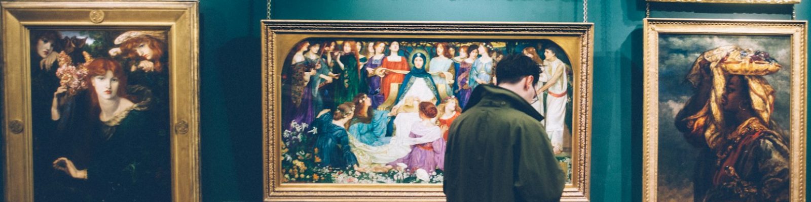 person standing near six paintings inside gallery